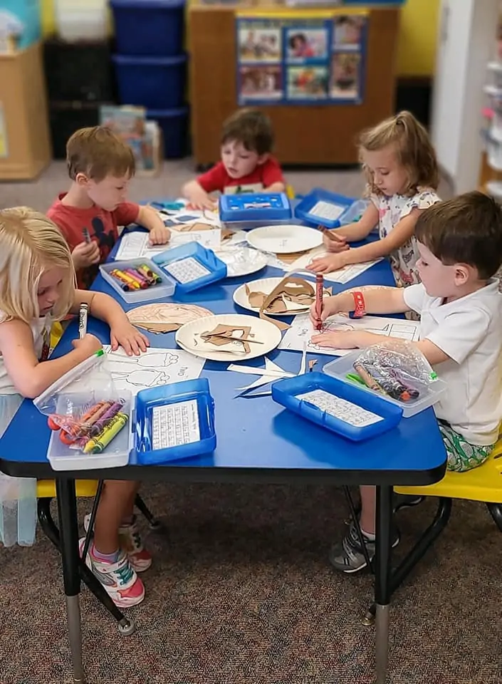 Children painting at an art station in an early learning center.