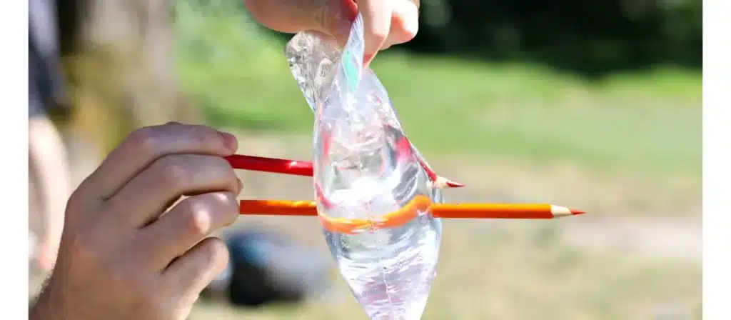 Fill a plastic bag with water, then carefully poke sharp pencils through the bag.