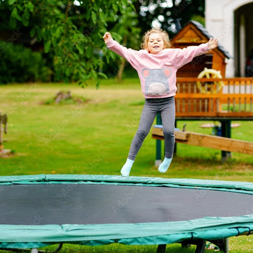 Little preschool girl jumping on trampoline