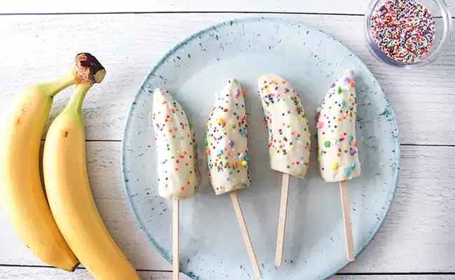 Banana pops dipped in yogurt and crushed nuts